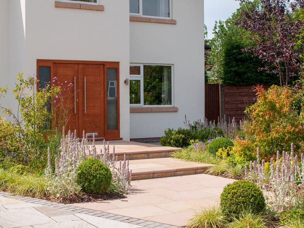 View of front garden designed by Natural Dimensions rising to front door including Carex Evergold, Astrantia, verbena boniarensis , Heuchera, stachys and buxus balls