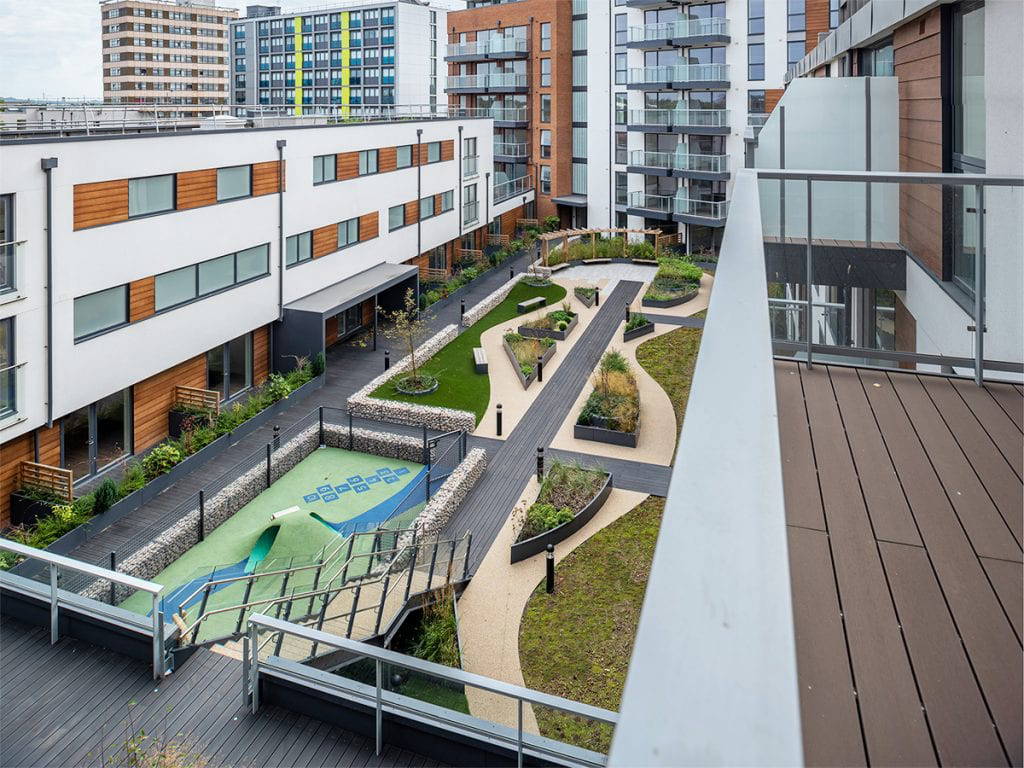 roof park on podium with central axis boardwalk along an array of sinuous shaped raised planters and sedum carpet which contain trees and grasses designed by Natural Dimensions.