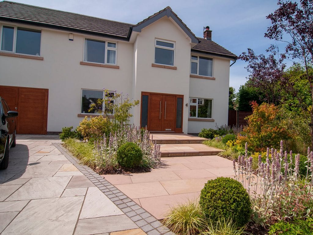 View of front garden designed by Natural Dimensions with steps rising to front door including Carex Evergold, Astrantia, verbena boniarensis , Heuchera, stachys and buxus balls