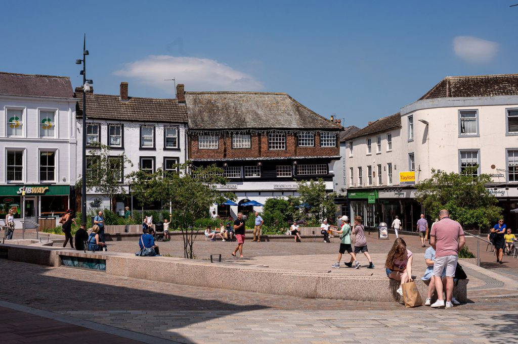 people sitting and meeting in Carlisle Greenmarket on a sunny day